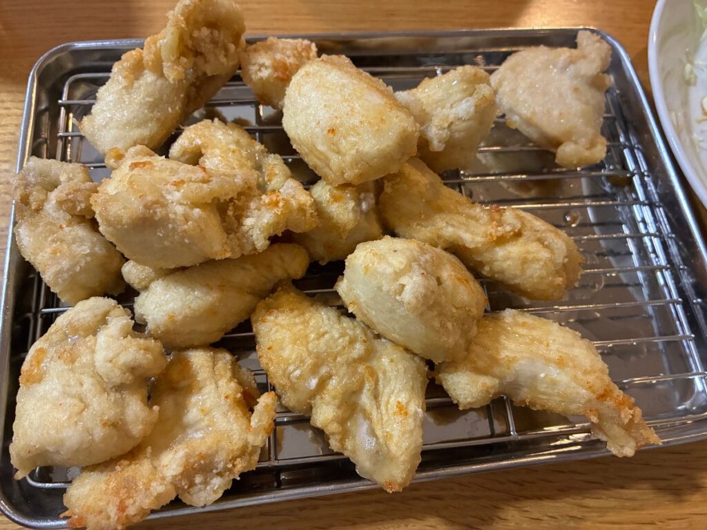 揚げ終わった鶏むね肉のぬか漬け唐揚げを網の上に並べた様子