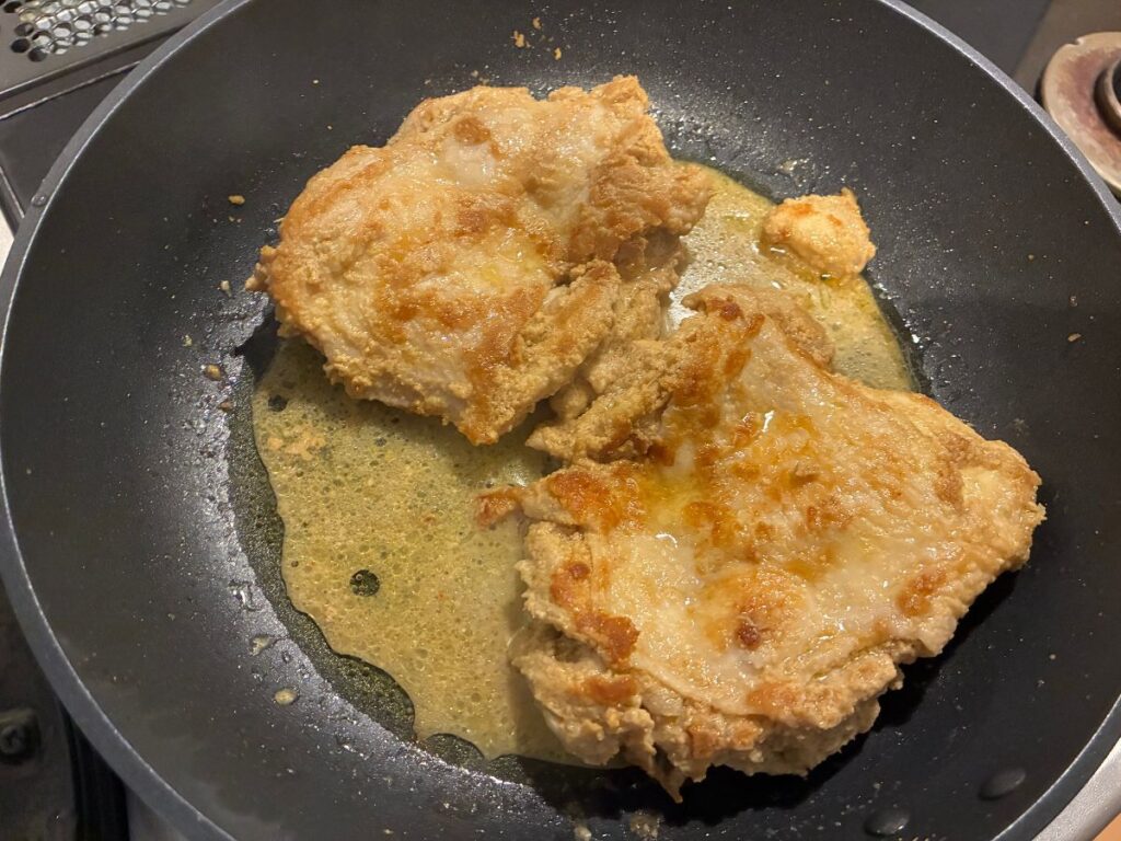 鶏もも肉を裏返し、両面に火を通している様子