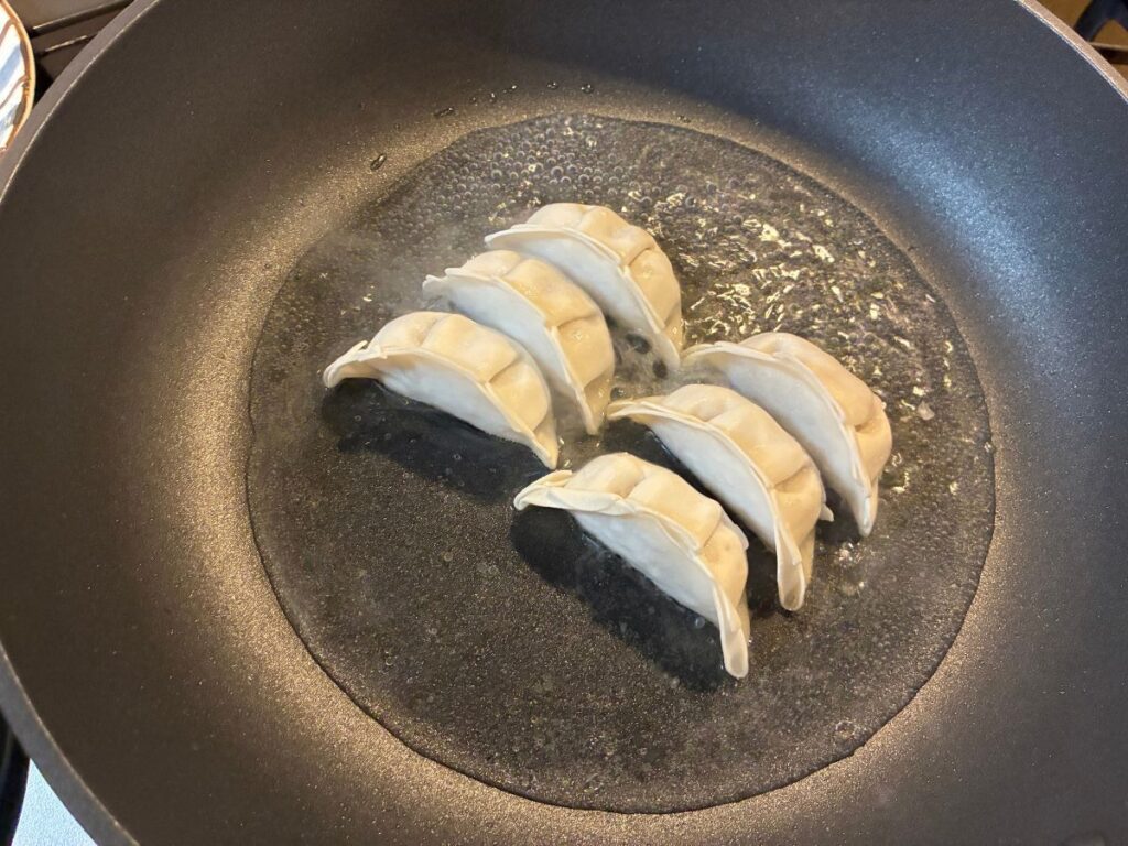 業務スーパーの生餃子に水を加えて蒸し焼きにする様子
