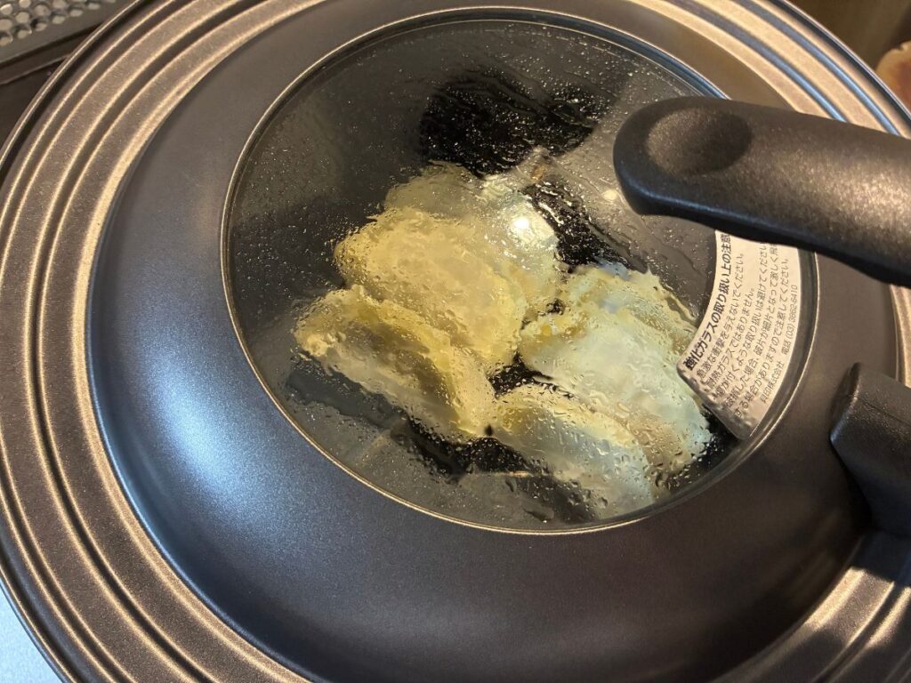 トップバリュ「ギョーザ」を蓋をして加熱している様子