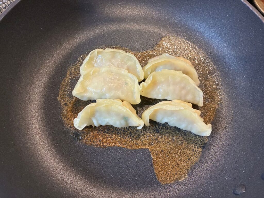 トップバリュ「ギョーザ」の羽根が色づいてきた焼き上がり直前の様子